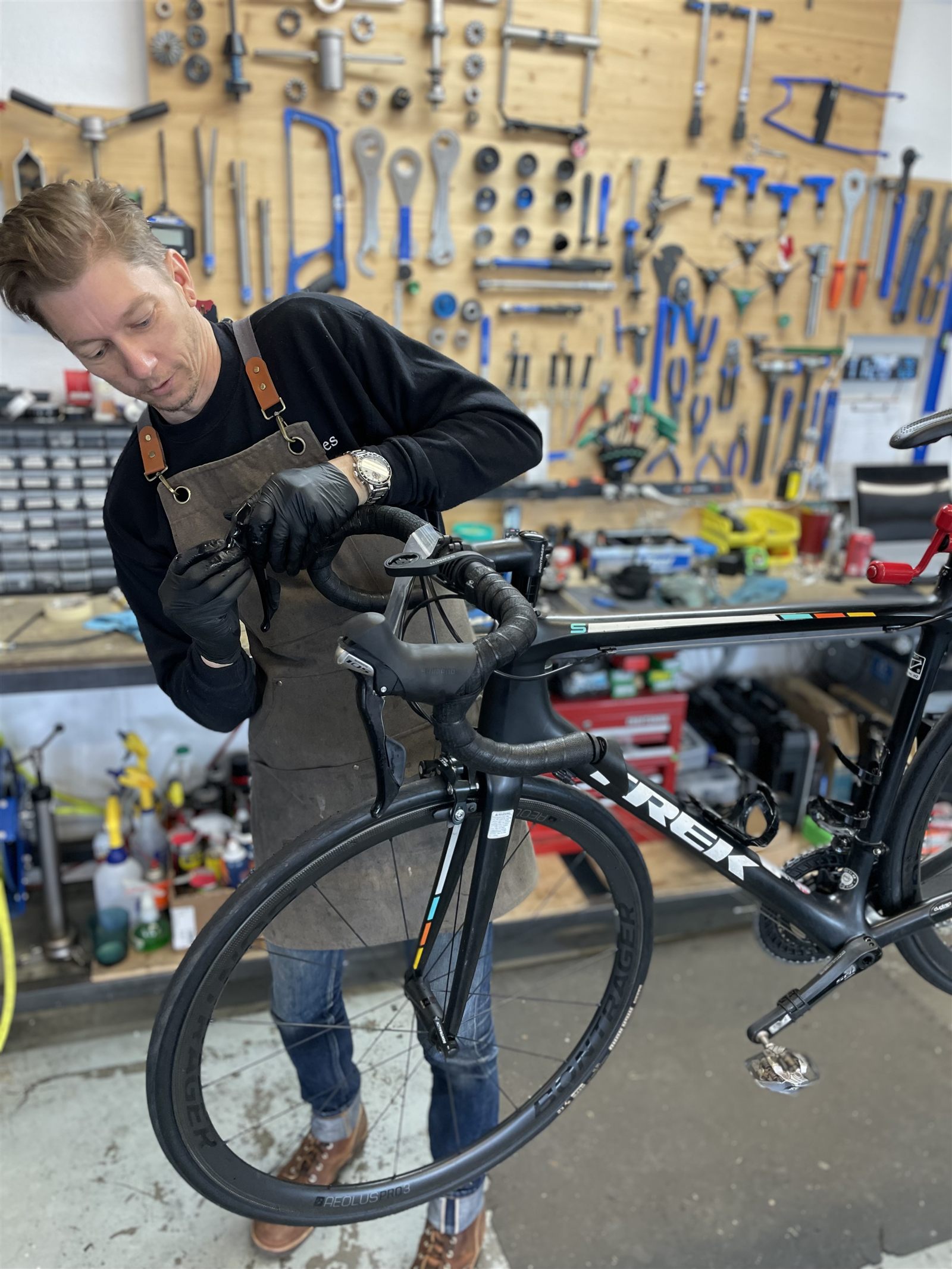 Michael Crum servicing a road bike shifter at the Magnolia Cycles workbench
