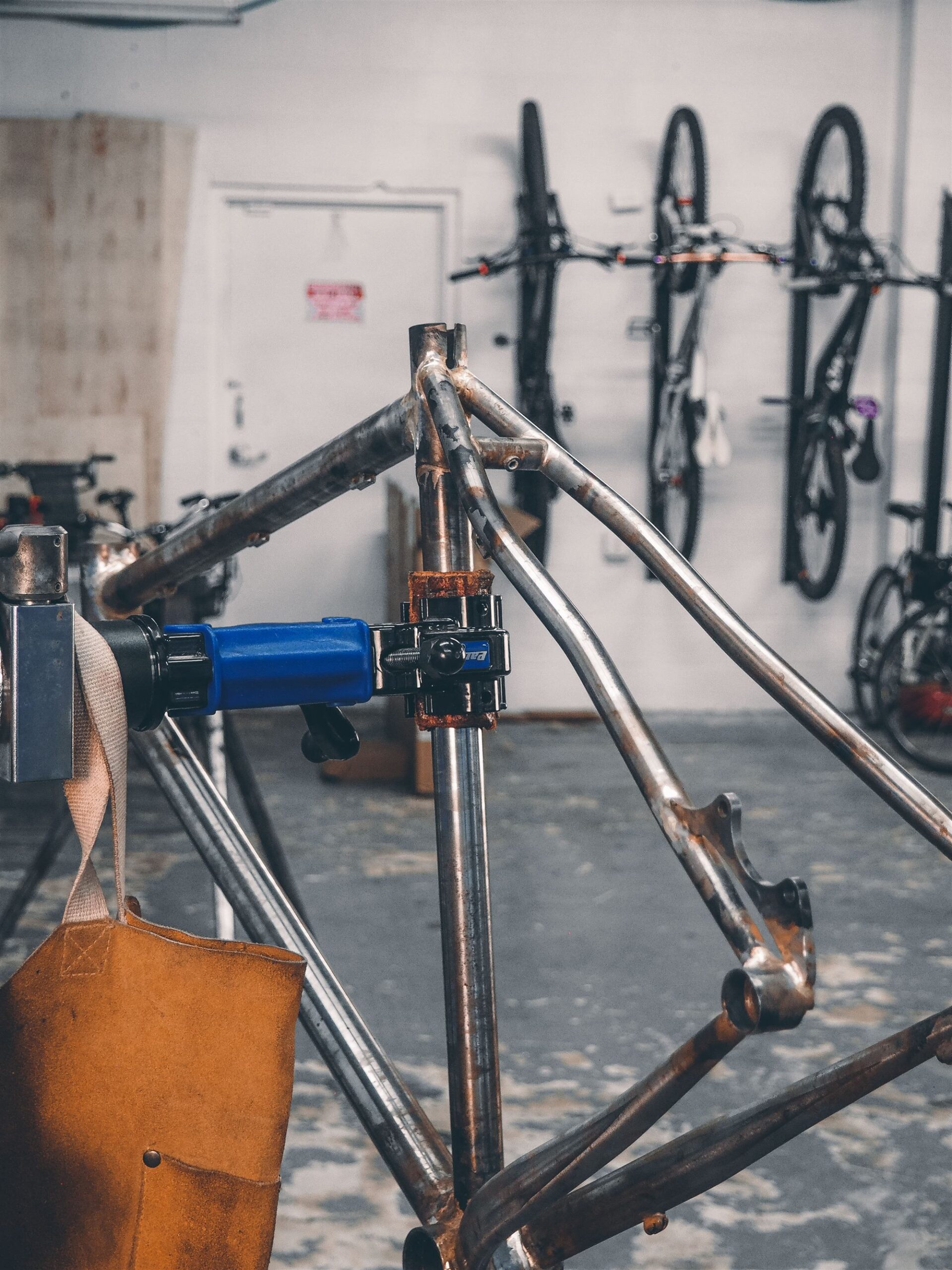 Completed custom steel frame in the work stand at Magnolia Cycles